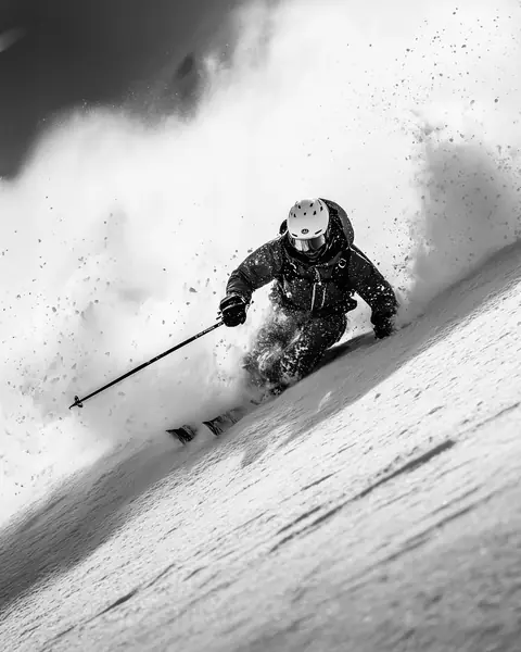 KI-generierte Schwarzweiß-Aufnahme: Skifahrer im Tiefschnee – gecaptured KI-Medien