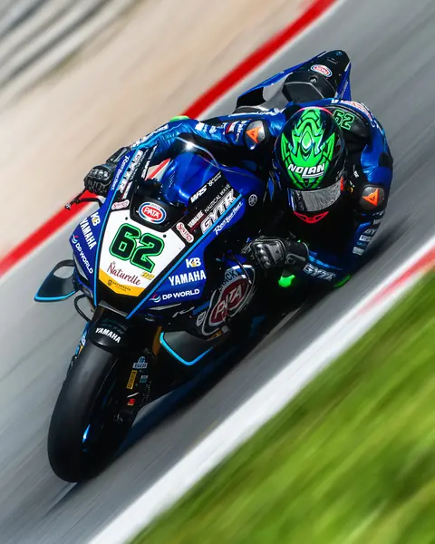 Blaues Rennmotorrad in Schräglage am Randstein
