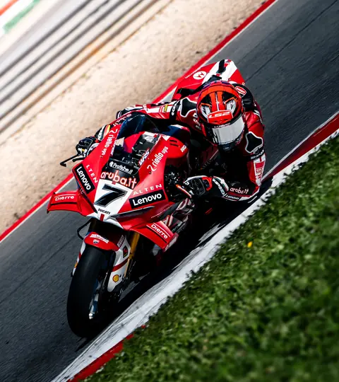 Rotes Rennmotorrad in Schräglage am Randstein