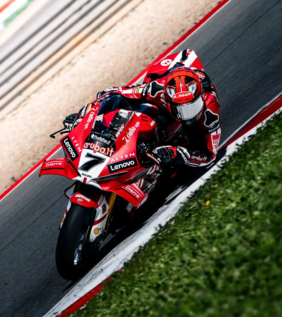 Rotes Rennmotorrad in Schräglage am Randstein
